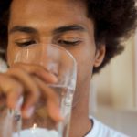 a-man-drinking-a-glass-of-water-as-it-s-one-of-many-dry-mouth-remedies